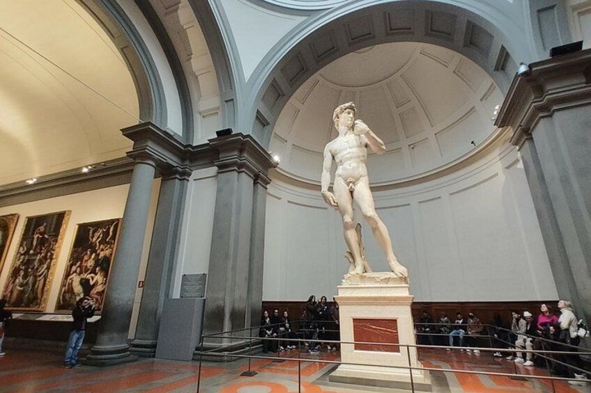 Una estatua clásica en un museo con techos altos y columnas. 1