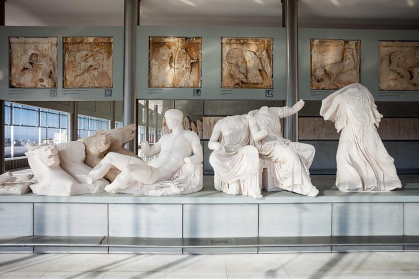 Une installation de sculptures en marbre dans un bâtiment moderne doté de grandes fenêtres. 3