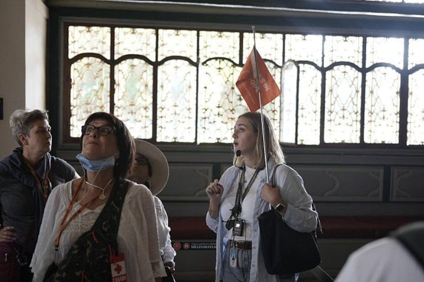 A group of people in a building with stained glass windows. 4