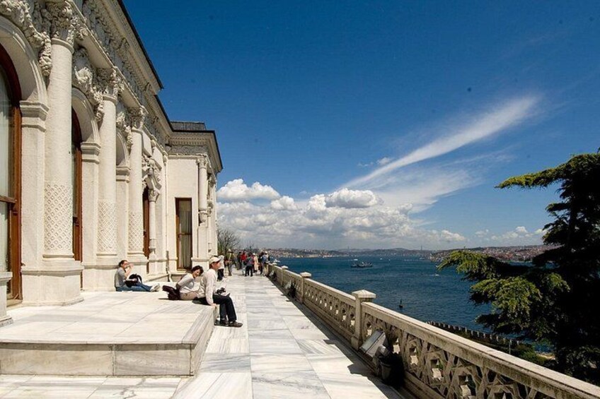 Un paseo marítimo con arquitectura clásica, cielo despejado y un paisaje urbano distante. 3