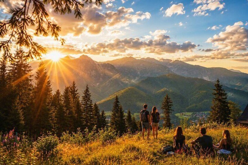 A group of people on a mountain overlooking a valley with a sunset. 3
