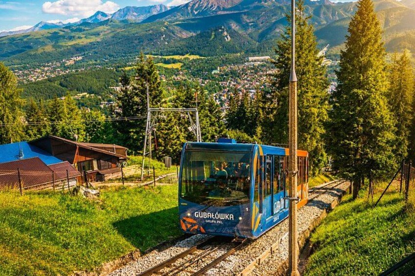 A cable car on tracks with a mountainous landscape in the background. 5