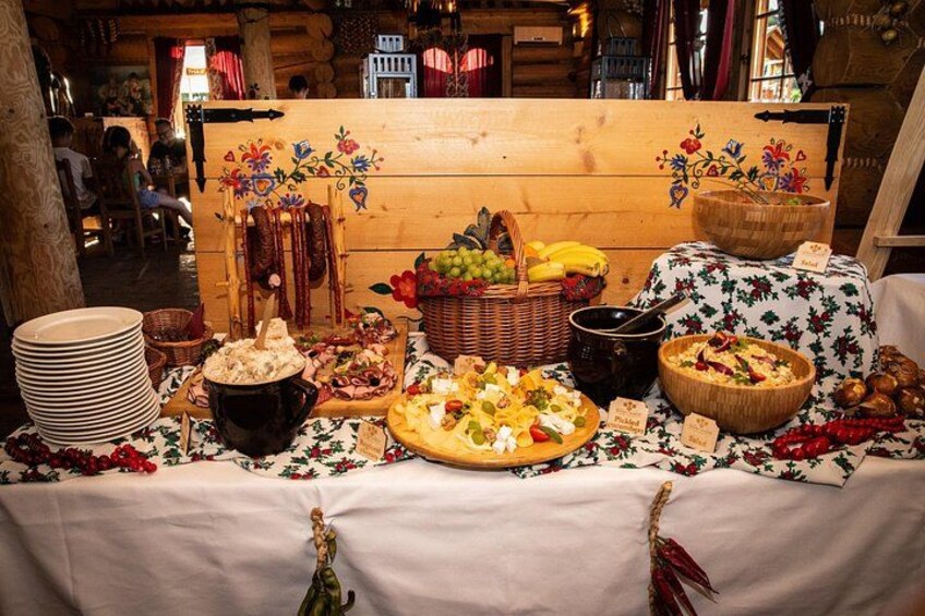 A table with various food items, including a pizza, fruits, and a pot of soup. 2