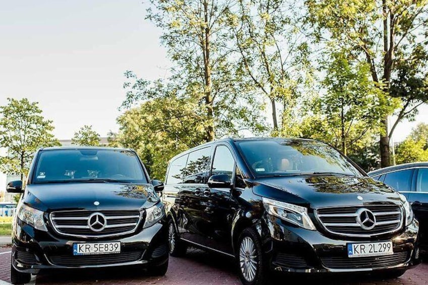 Two black Mercedes-Benz vehicles parked outdoors with trees in the background. 5