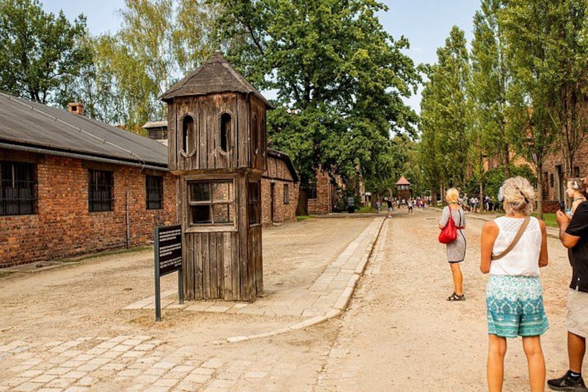 Ein historisches Gebäude mit Holzkonstruktion, Backsteinwand und einem gepflasterten Weg. 4