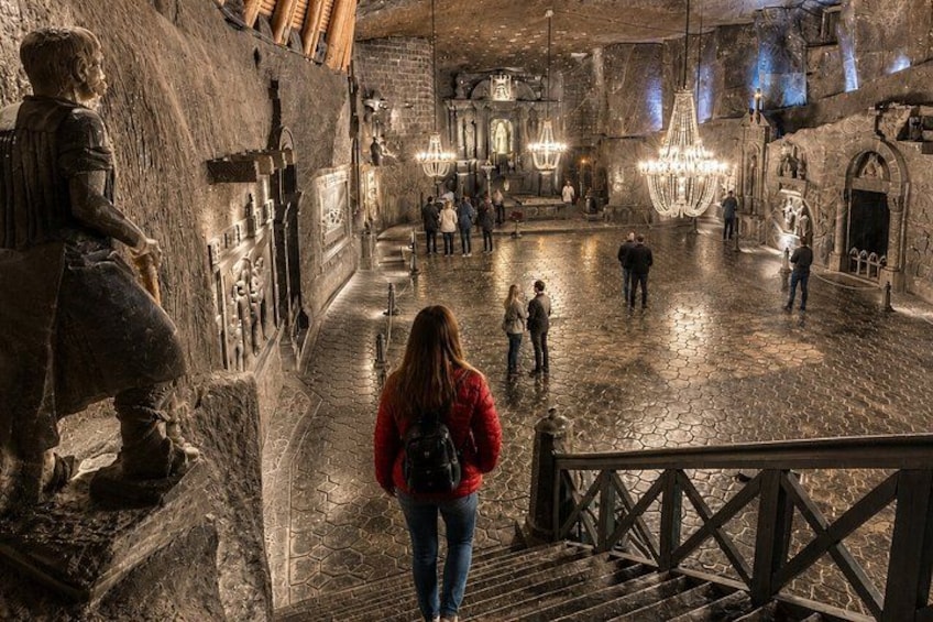 A historical site with stone walls, a staircase, and visitors. 3