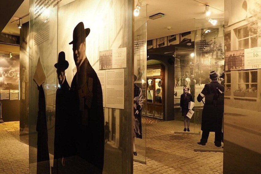 Una mostra museale con figure storiche e pannelli informativi. 2