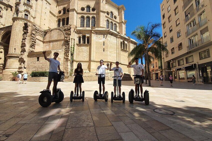 People on Segways in front of a historic building with palm trees. 1
