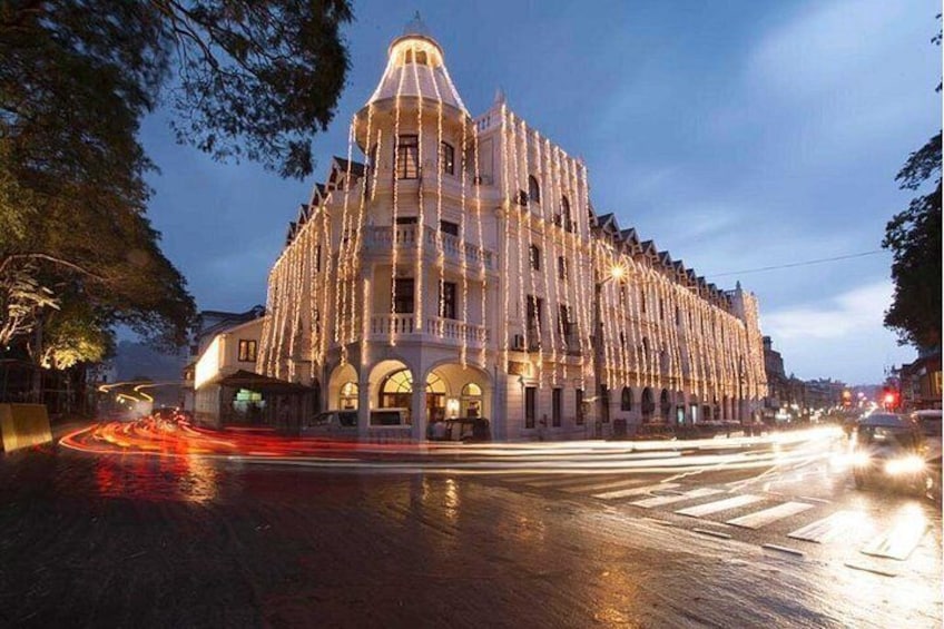 Un edificio histórico con ventanas de arco y una cúpula, iluminado con luces colgantes. 4