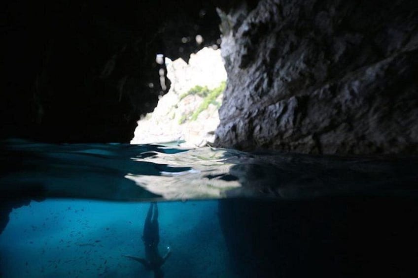 An underwater cave with clear water and a diver. 4