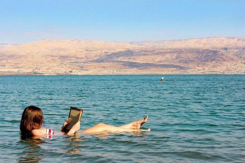 A person swimming in a body of water with a desert landscape in the background. 2