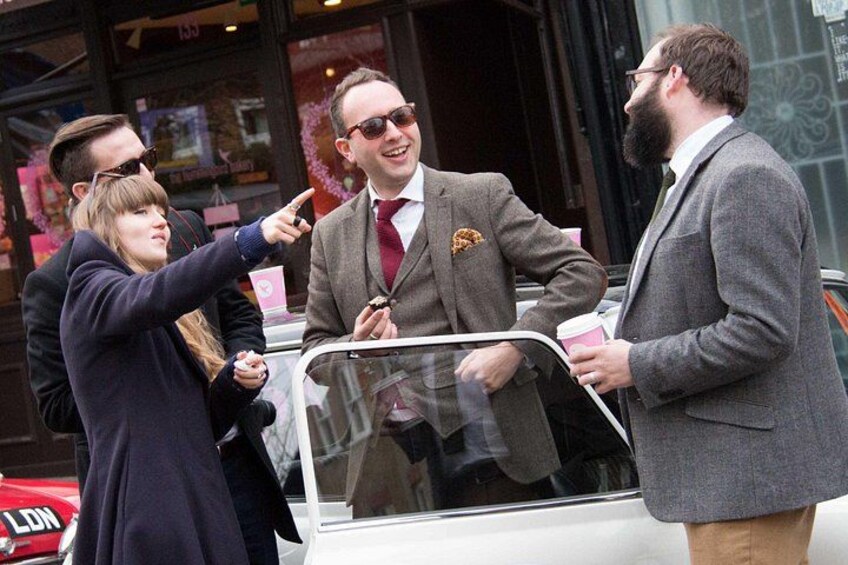 A street scene with a white car, a person in a suit, and another person pointing. 3