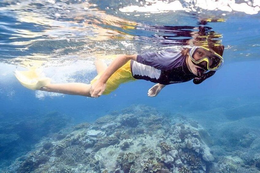 Une personne faisant de la plongée avec tuba sous l’eau, avec une visibilité claire du fond de l’océan. 3
