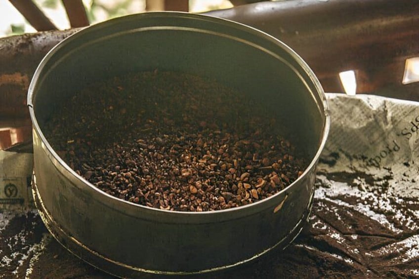 A metal container filled with coffee beans on a wooden surface. 5