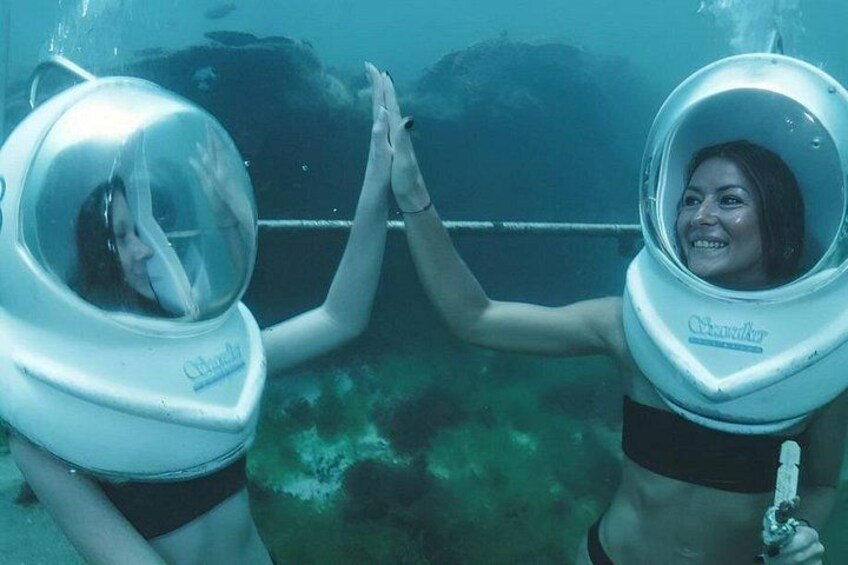 Two individuals in scuba diving gear underwater. 2