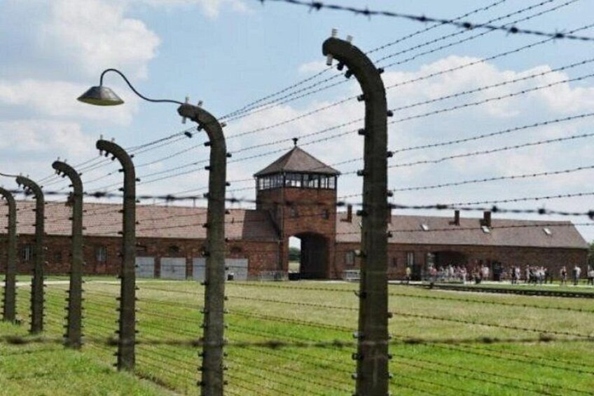 Barbed wire fences, a watchtower, and a brick building. 3