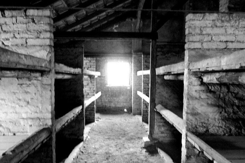 A rustic wooden structure with a sloped roof, wooden beams, and a window allowing natural light to enter. 2