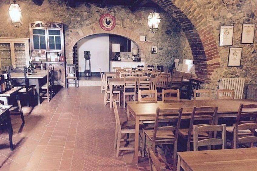 Ein rustikales Restaurant mit Backsteinbögen, Holztischen und einer Steinwand. 3