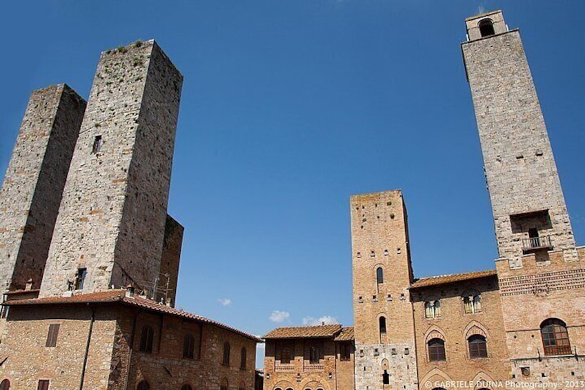 A historic building with two prominent towers and a smaller adjacent structure. 2