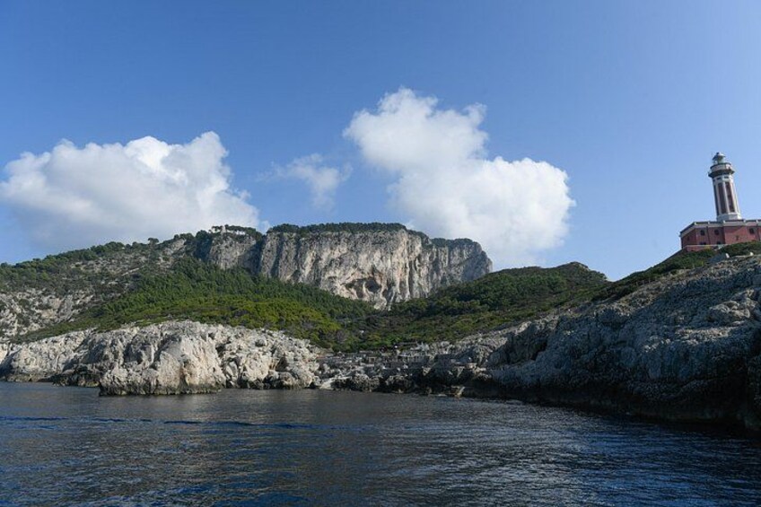 A coastal landscape with a lighthouse, rocky cliffs, and a clear sky. 4