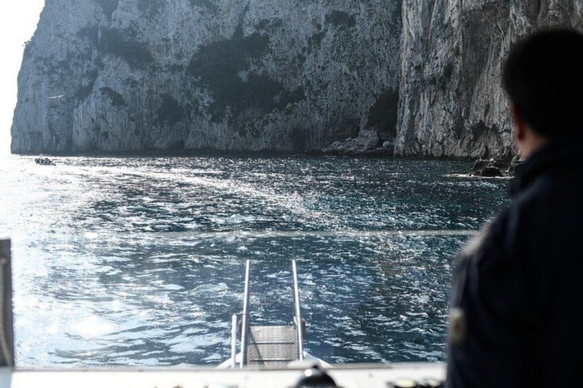 Une personne se trouve sur un bateau, près d'une côte rocheuse. 2