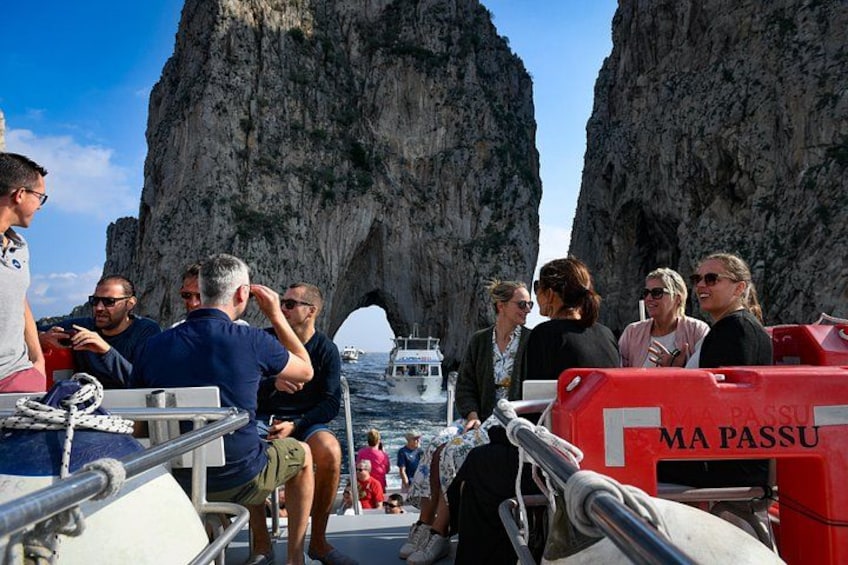 Eine Gruppe von Menschen auf einem Boot vor einer Felsformation. 3