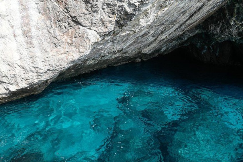 L'ingresso di una grotta rocciosa con acqua cristallina di colore turchese. 1