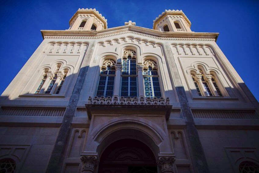 A large, ornate building with a prominent arched entrance and multiple windows with intricate designs. 2