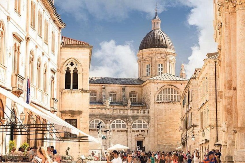 Un edificio histórico con una cúpula, un paseo cubierto y una multitud de personas. 4