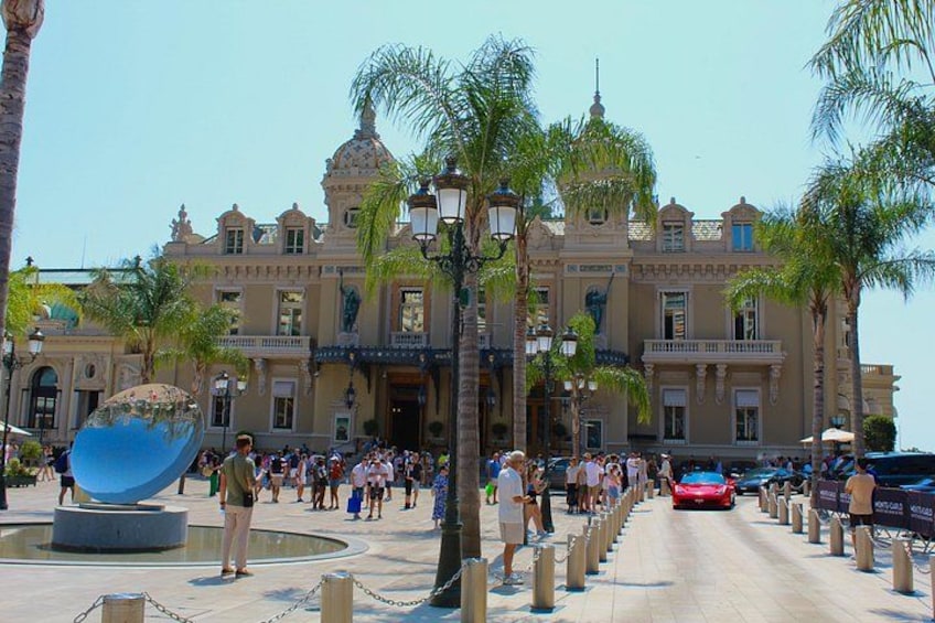 Un grand bâtiment doté d’un dôme et de colonnes, bordé de palmiers, et où se trouve une foule de personnes. 2