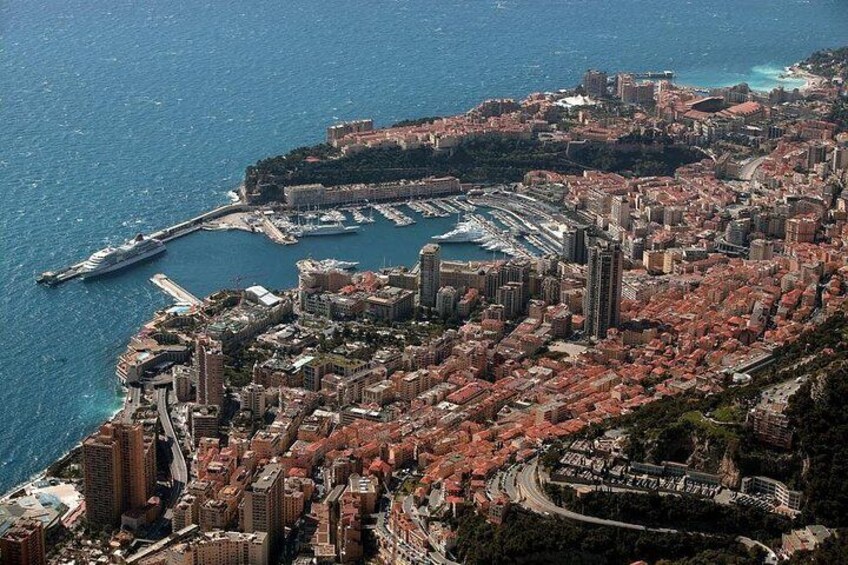 A coastal city with dense urban development, a marina, and a prominent waterfront promenade. 2