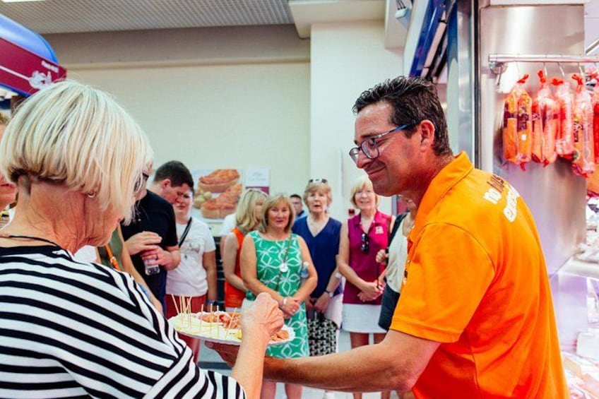 A person in an orange shirt handing a plate to another person. 4