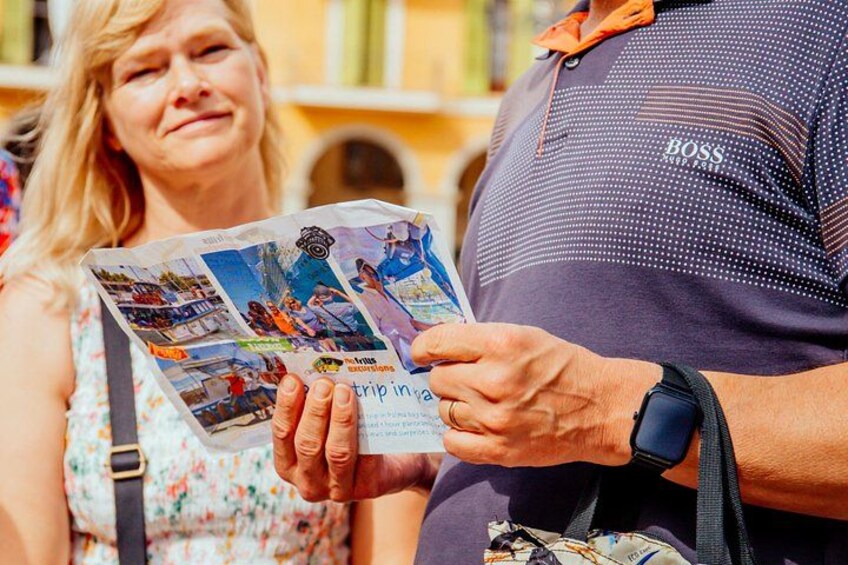 En person holder en rejsebrochure med billeder af forskellige destinationer. 3