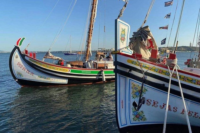 Two traditional sailing boats docked at a harbor with flags and decorative elements. 2