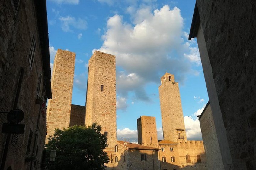 A medieval stone tower with a clock, surrounded by old buildings. 2