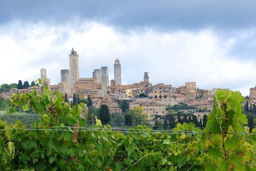 A historic cityscape with medieval architecture, including towers and fortified walls. 3