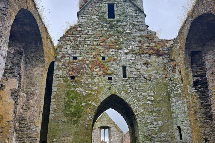 Un arco de piedra que conduce a una torre con un pequeño ventanal. 3