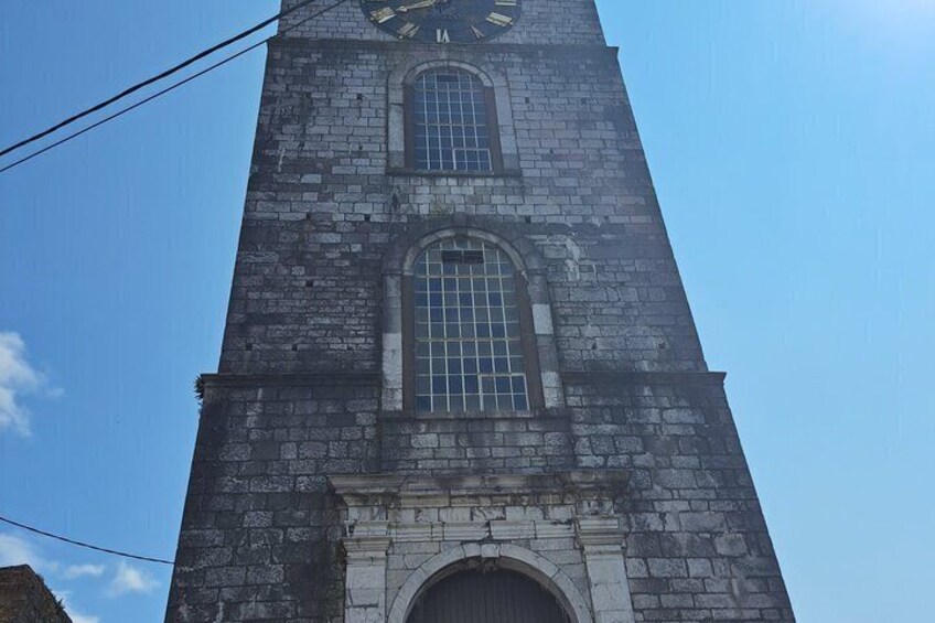 Une haute tour d’horloge en pierre, avec un ciel bleu clair en arrière-plan. 3