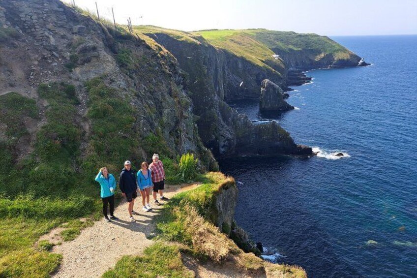 Un sentier de randonnée le long de la côte, avec des falaises rocheuses et l’océan. 4
