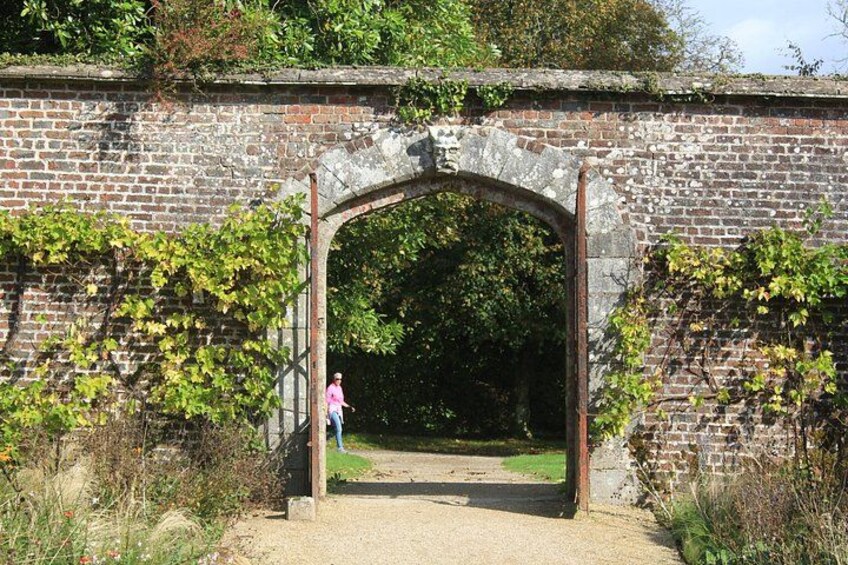 A brick archway with greenery on either side. 2