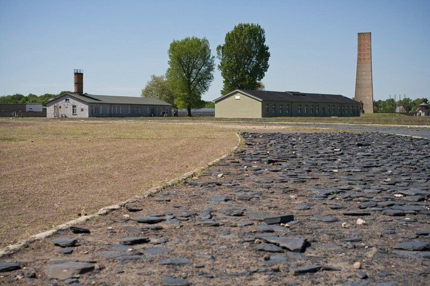 A paved pathway, a building, a tree, and a tall chimney. 4