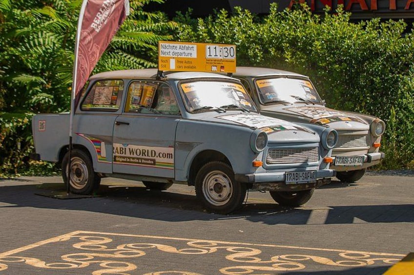 A vintage car with a sign indicating the next departure time. 2