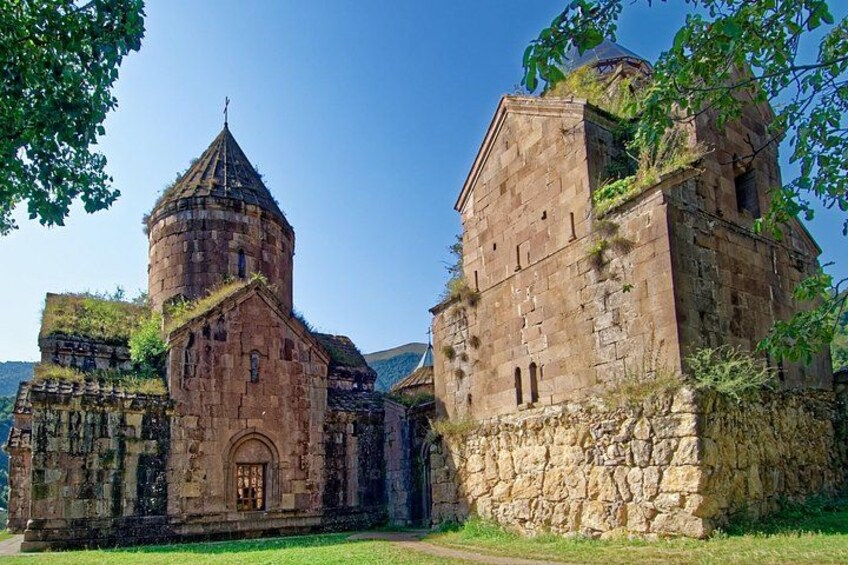 A historic stone building with a bell tower and a large arched doorway. 2