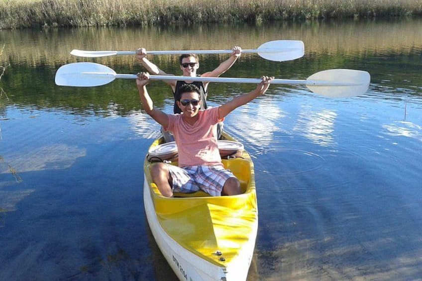 Two people in a yellow canoe on calm water, holding paddles. 1