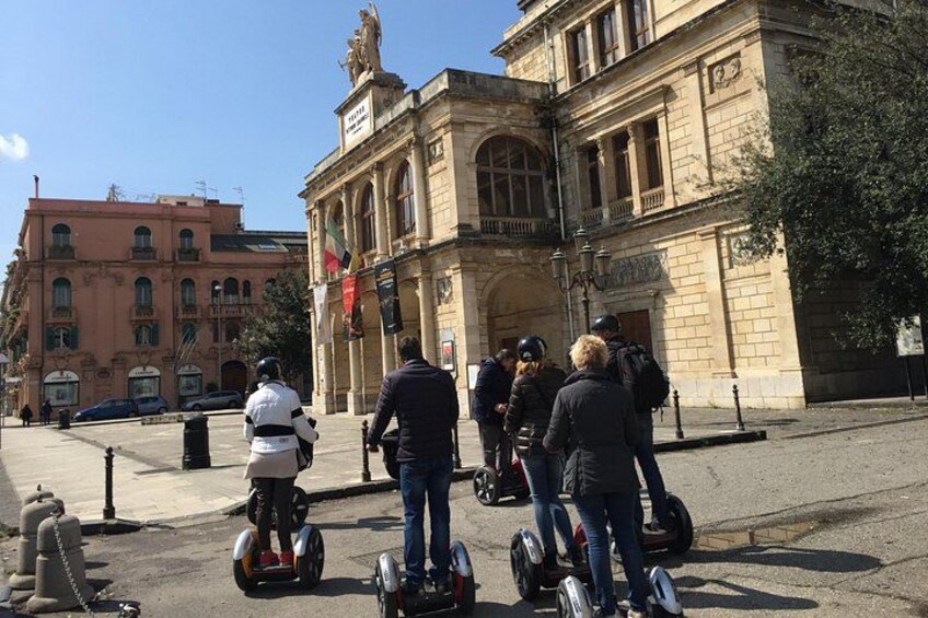 Un grupo de personas montando Segways frente a un edificio histórico con columnas y estatuas. 5