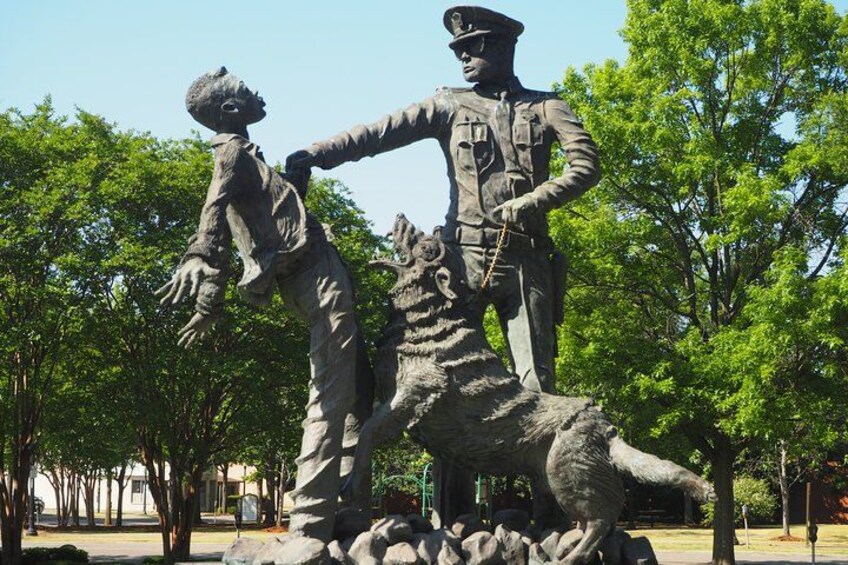A statue of a man with a dog in a park. 2
