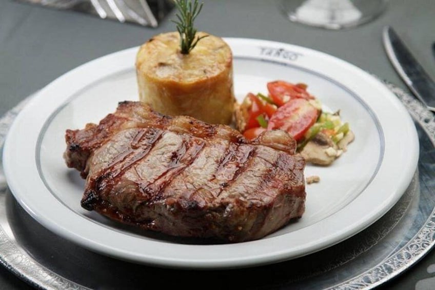 Un plato con un bistec a la parrilla, una patata al horno y una ensalada. 4