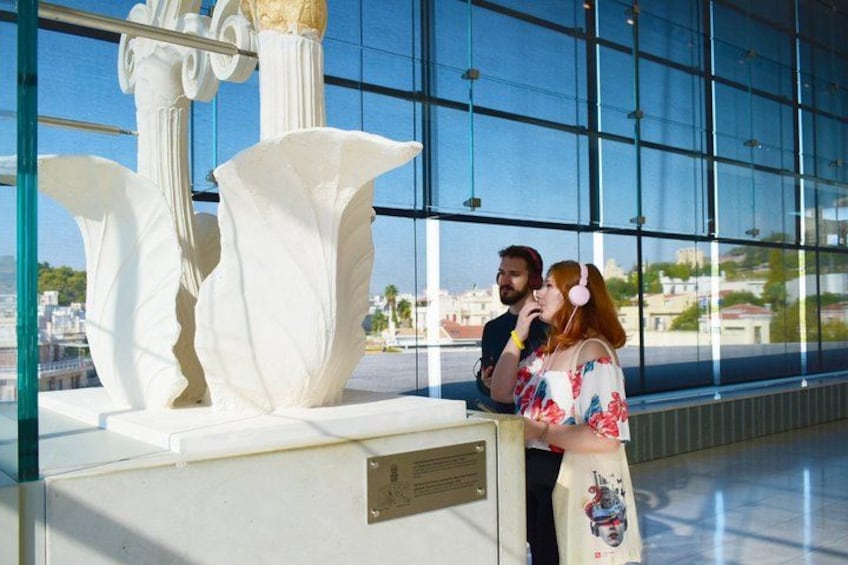 A couple standing in front of a white sculpture in a modern building with large windows. 2