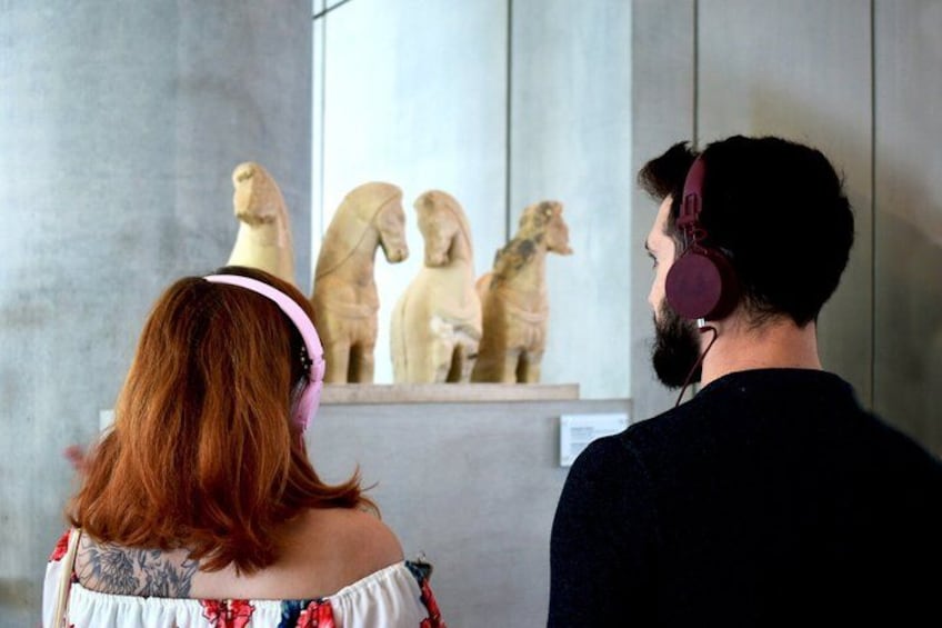 Two people observing a display of dinosaur sculptures. 5