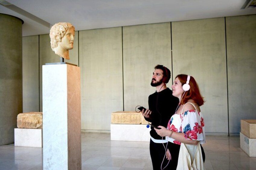 A bust sculpture in a modern interior space with a man and a woman using virtual reality headsets. 3